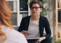 Counselor and client talking on a couch during a therapy session for early recovery anxiety