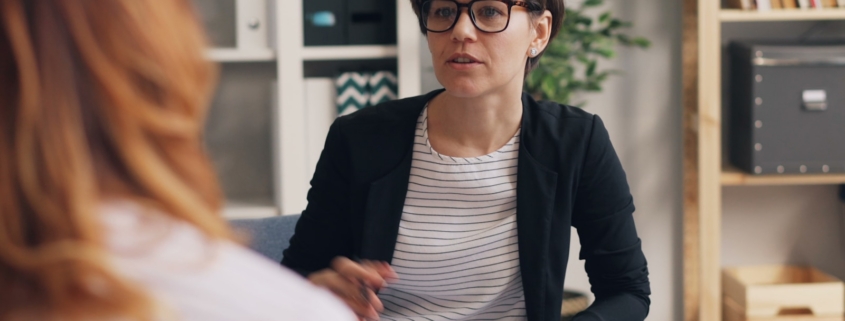 Counselor and client talking on a couch during a therapy session for early recovery anxiety
