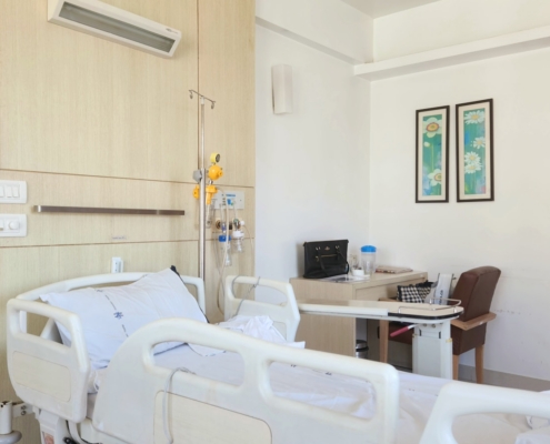 private inpatient treatment room with a hospital bed and IV pole