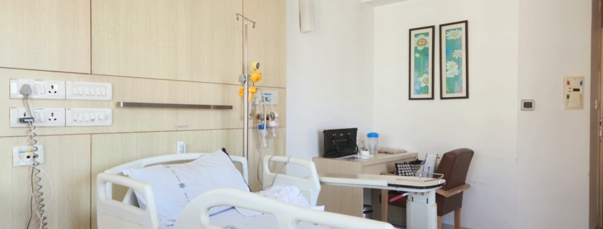 private inpatient treatment room with a hospital bed and IV pole