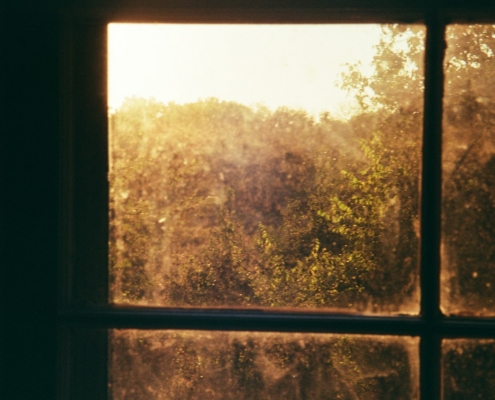A person sitting quietly in low natural light