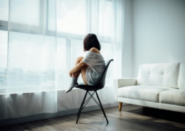 Person sitting by a window reflecting on depression after quitting alcohol