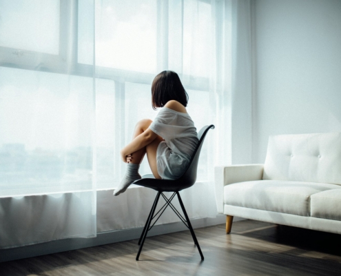 Person sitting by a window reflecting on depression after quitting alcohol