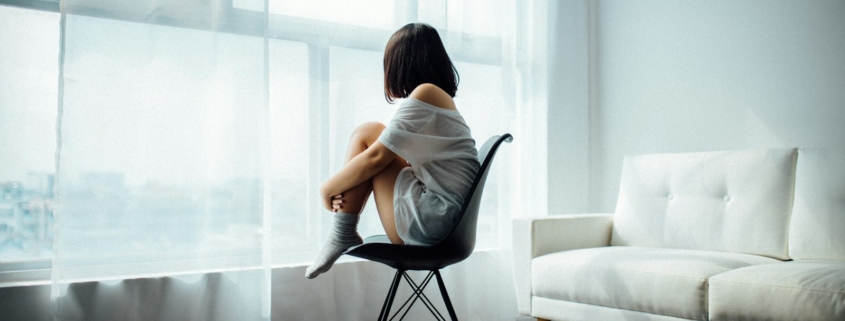 Person sitting by a window reflecting on depression after quitting alcohol