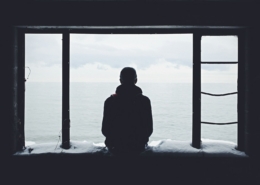 A person sitting quietly by a window in soft daylight