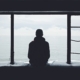 A person sitting quietly by a window in soft daylight