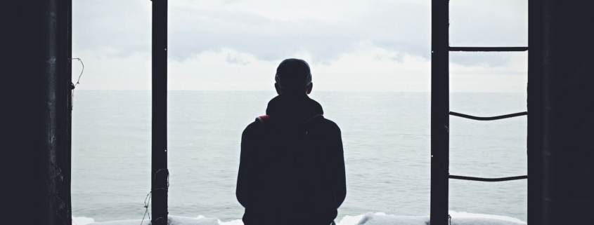 A person sitting quietly by a window in soft daylight