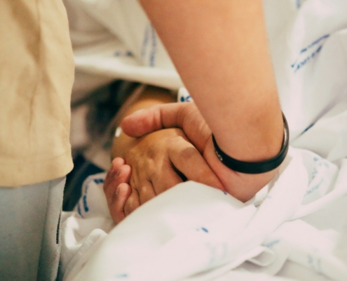 how families support a loved one during medical detox - hand holding support at bedside