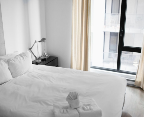 Bright, calm bedroom with a neatly made bed, illustrating restored sleep in early recovery