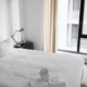 Bright, calm bedroom with a neatly made bed, illustrating restored sleep in early recovery