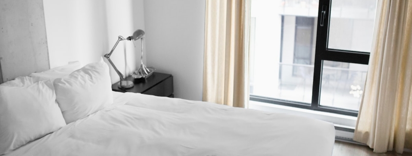 Bright, calm bedroom with a neatly made bed, illustrating restored sleep in early recovery