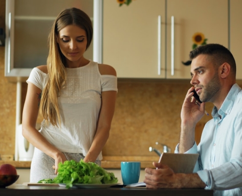 Family member sitting at a kitchen table in worried thought, representing the difficult position of having a loved one who refuses treatment